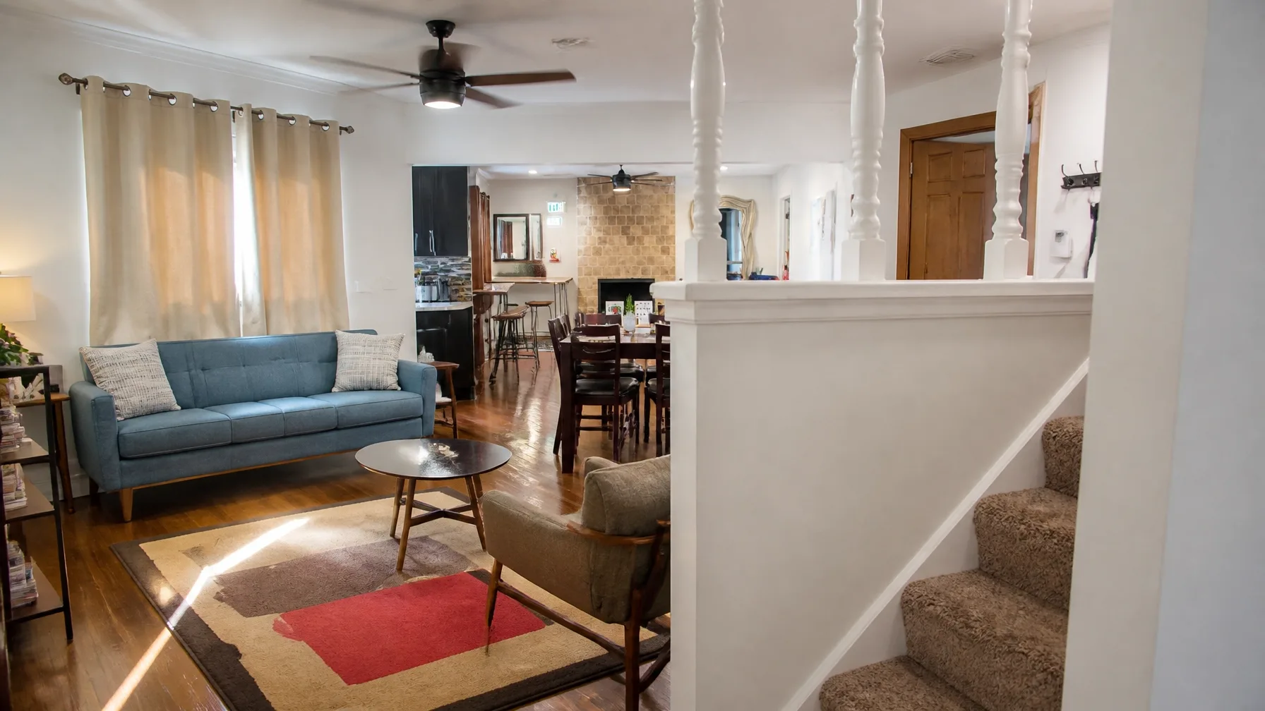A bright, clean, and welcoming shared living room in a modern home, emphasizing a safe and stable environment for recovery.